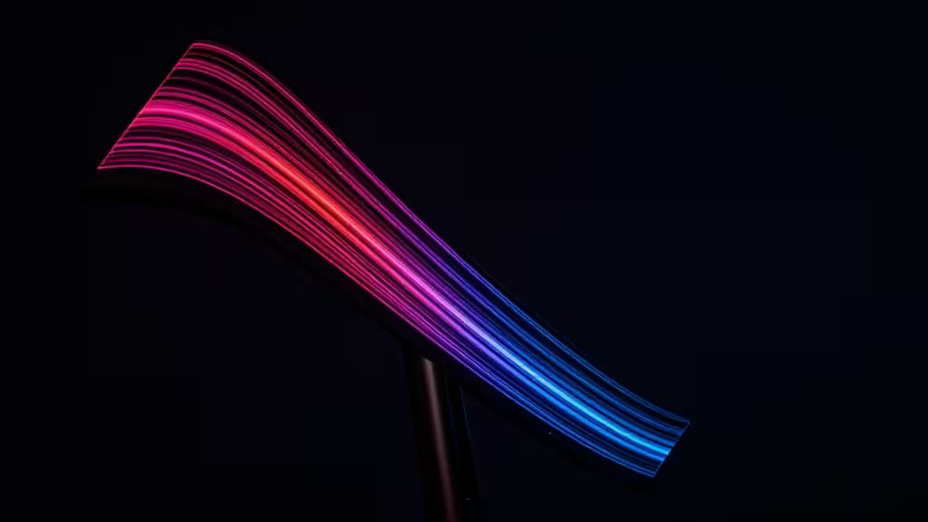 Curved OLED panel displays vibrant pink-to-blue gradient lines against deep black background, emphasizing contrast and color accuracy.