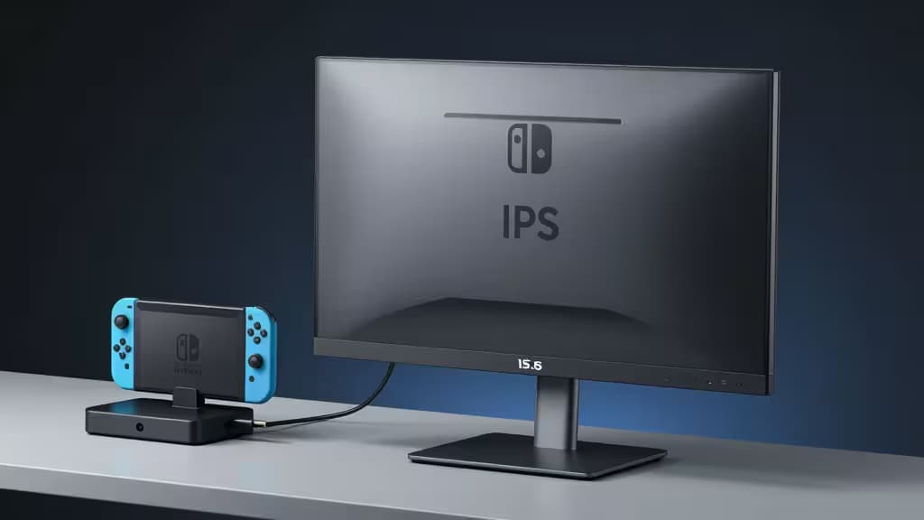 A Nintendo Switch docked beside a sleek 15.6-inch IPS portable monitor on a minimalist desk.