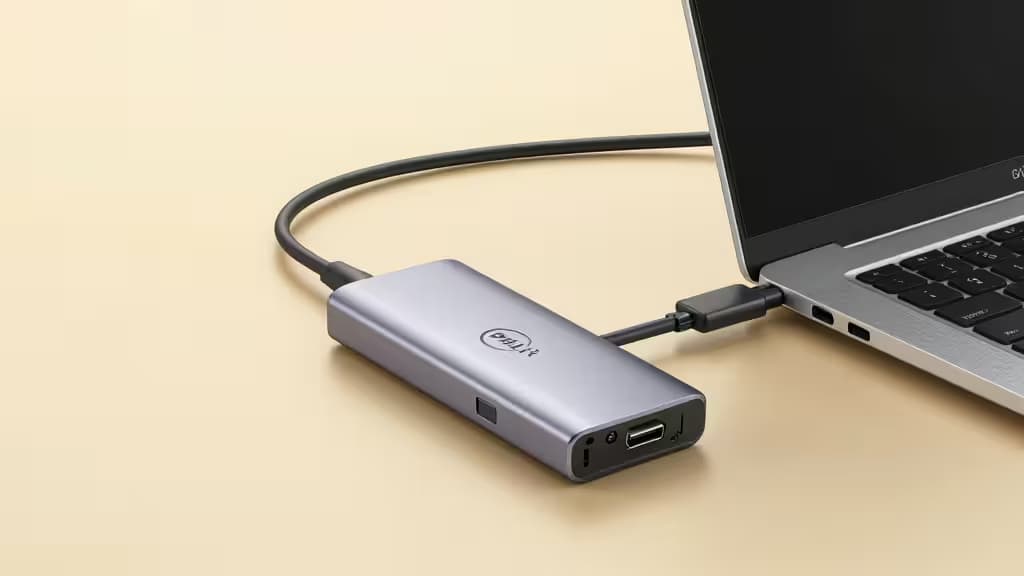 Silbernes Dell USB-C Hub mit HDMI und USB-Anschlüssen, verbunden mit einem XPS-Laptop.