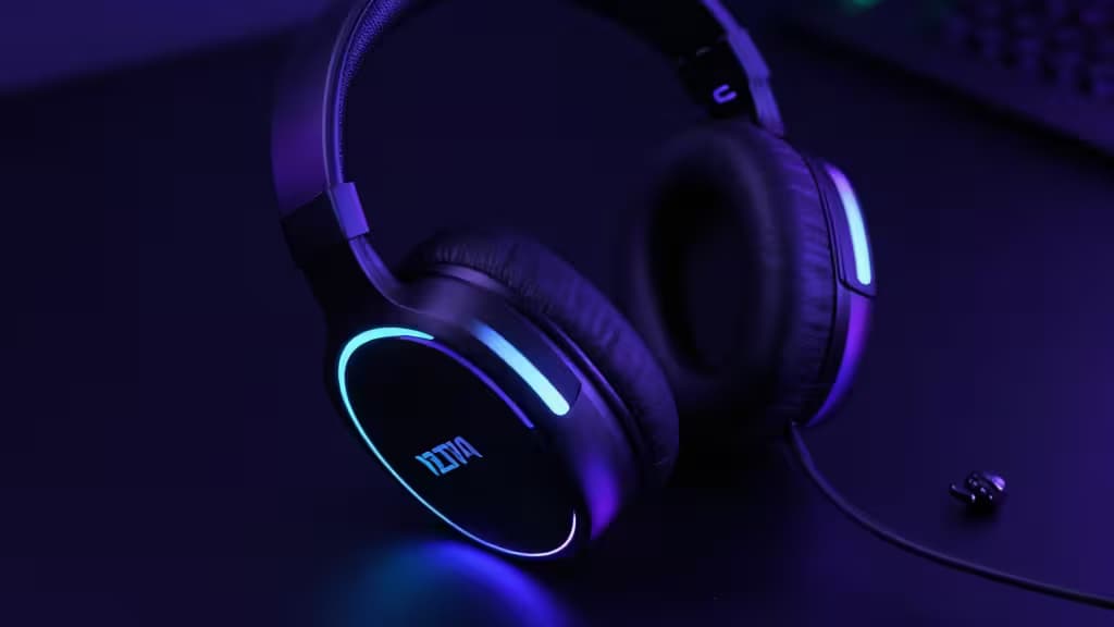 Un casque gaming noir élégant avec des accents LED bleus posé sur une surface sombre, mettant en valeur son design moderne et son logo.