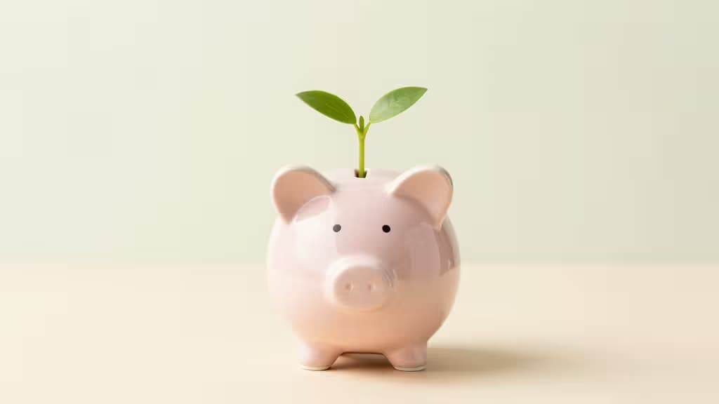 Ein wachsender Sparschwein mit einem kleinen grünen Keimling, der aus dem Münzschlitz sprießt – Symbol für finanzielles Wachstum.