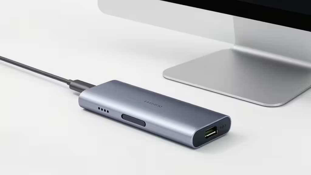 Sleek aluminum USB-C hub connects to Mac Studio, featuring multiple ports and minimalist design.