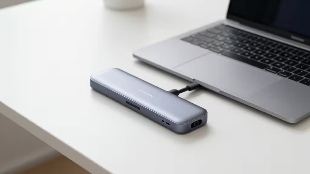 Sleek silver Thunderbolt 4 dock connects to Windows laptop on white desk.