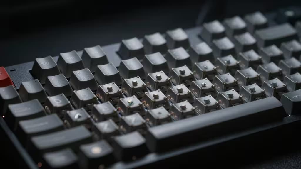 Compact mechanical keyboard with exposed switches and gray keycaps, angled shot highlighting build quality for budget buyers.