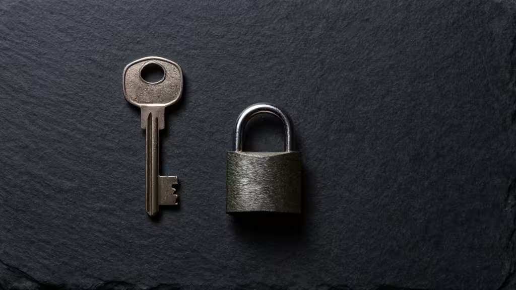 A vintage key and padlock rest on dark slate, symbolizing secure offline password management.