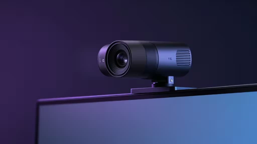 A sleek 4K webcam mounted on a modern monitor under cinematic studio lighting with soft purple and blue accent glow.
