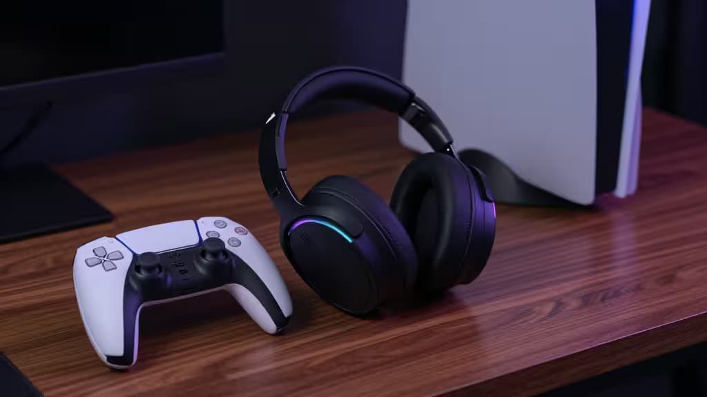 Black PS5 headset and white DualSense controller rest on wood desk under moody lighting.