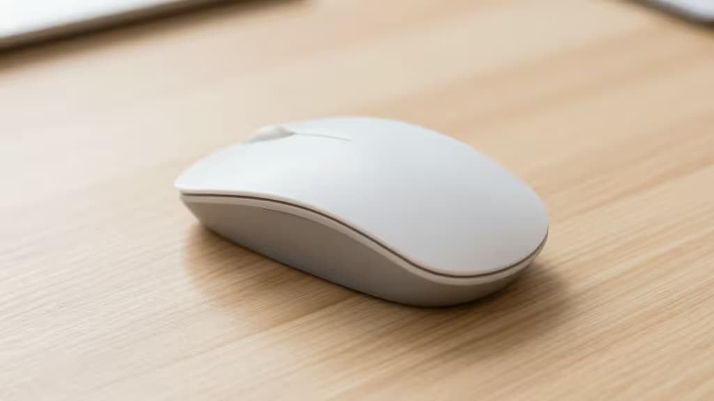 White ergonomic mouse rests on light wood desk, illustrating affordable carpal tunnel relief.