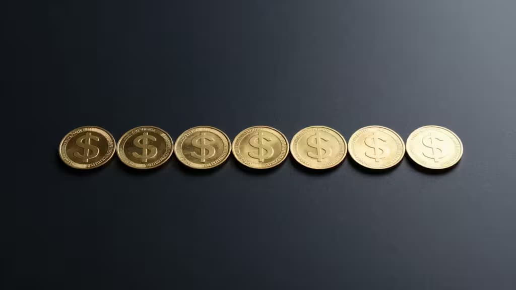 Golden coins with dollar symbols arranged on a dark surface, representing stablecoin savings and yield earning