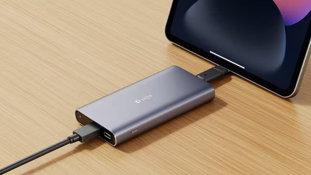 Sleek aluminum USB-C hub connects to iPad Pro 2024 on wood desk.