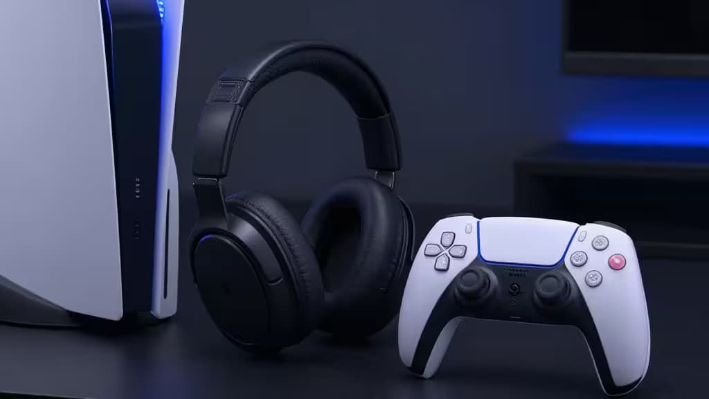 Casque PlayStation 5 noir posé à côté d'une console PS5 blanche et d'une manette DualSense sur une surface sombre
