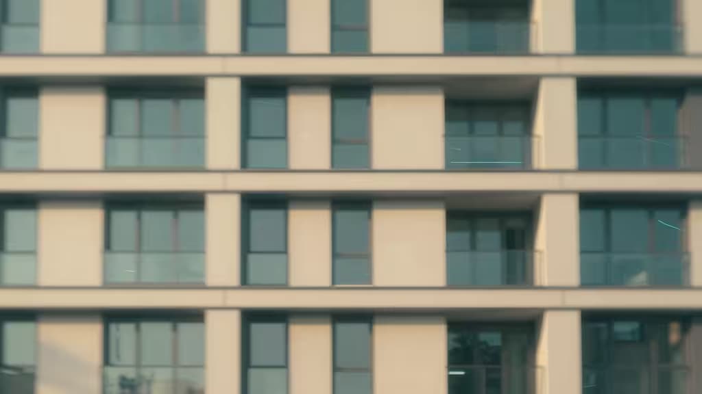 Moderne appartementengebouw met glazen ramen en beige panelen, passend bij property management context.