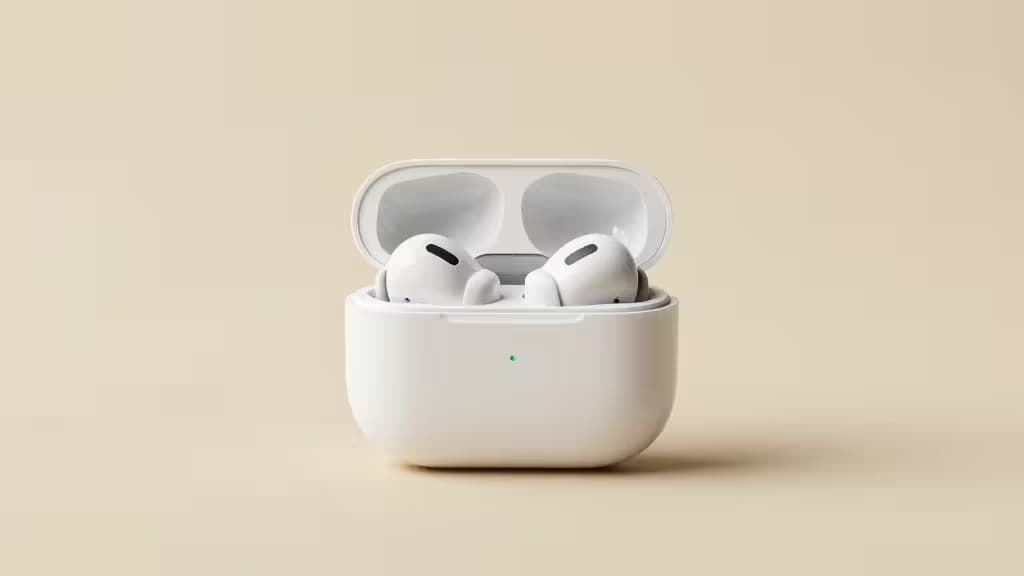 Écouteurs sans fil blancs reposant dans leur boîtier de charge ouvert, centrés sur un fond beige doux.