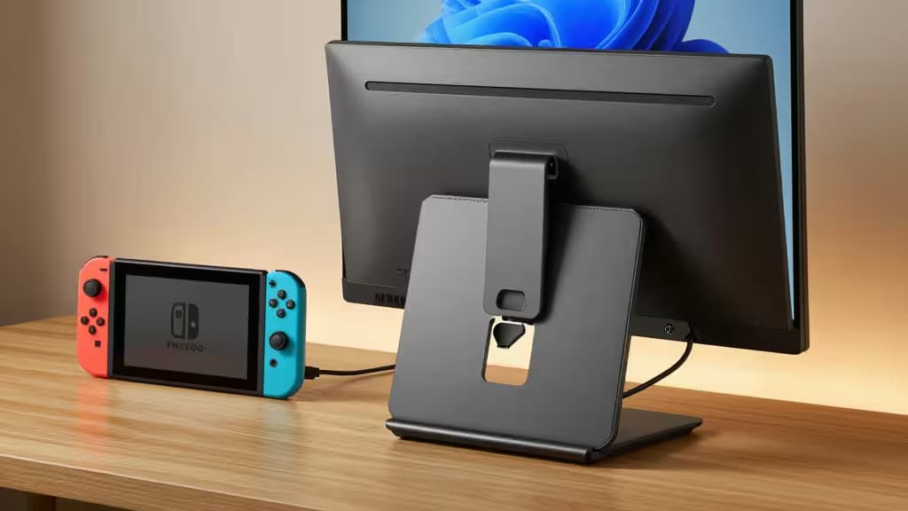 Un moniteur portable 15,6 pouces IPS avec un smart cover repliable posé sur un bureau en bois, relié par USB-C à une Nintendo Switch.