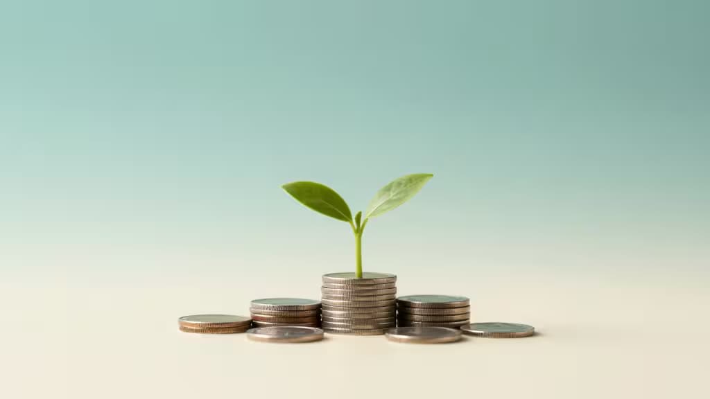 A small green seedling growing from stacked coins against a soft teal and cream gradient background, symbolizing beginner investing and growth.
