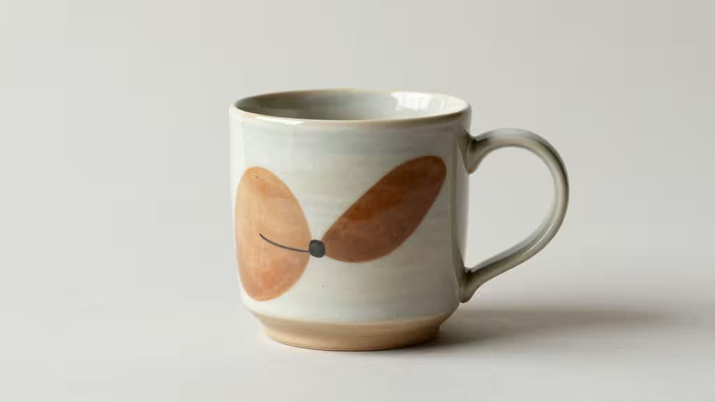Taza de cerámica artesanal con diseño abstracto de hoja marrón, fotografiada sobre fondo blanco para listado de Etsy.