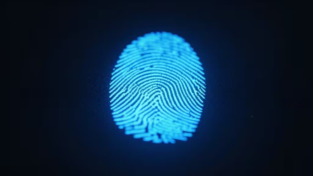 Glowing blue fingerprint biometric sensor on a dark surface, representing biometric security for password managers.