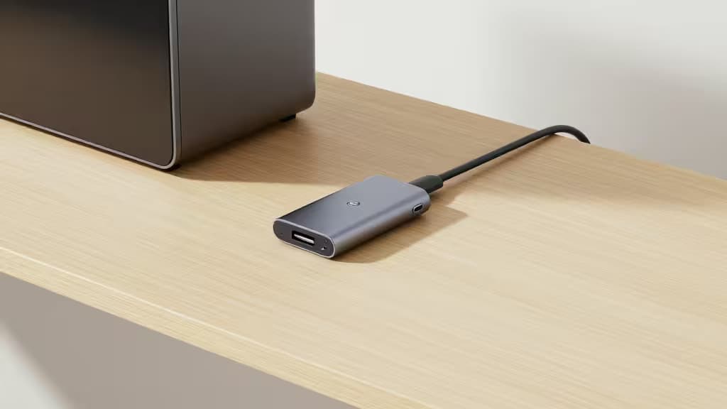 Sleek aluminum Mac Studio hub with USB-C port rests on light wood desk beside Mac Studio.