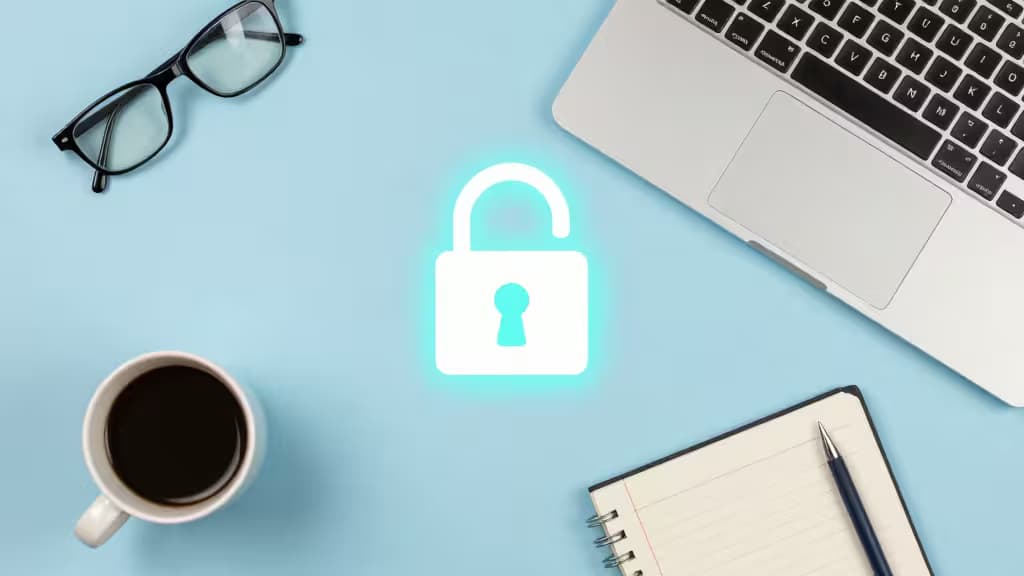 Un cadenas lumineux flotte au-dessus du bureau d'un freelance avec un ordinateur portable, un café et un carnet.