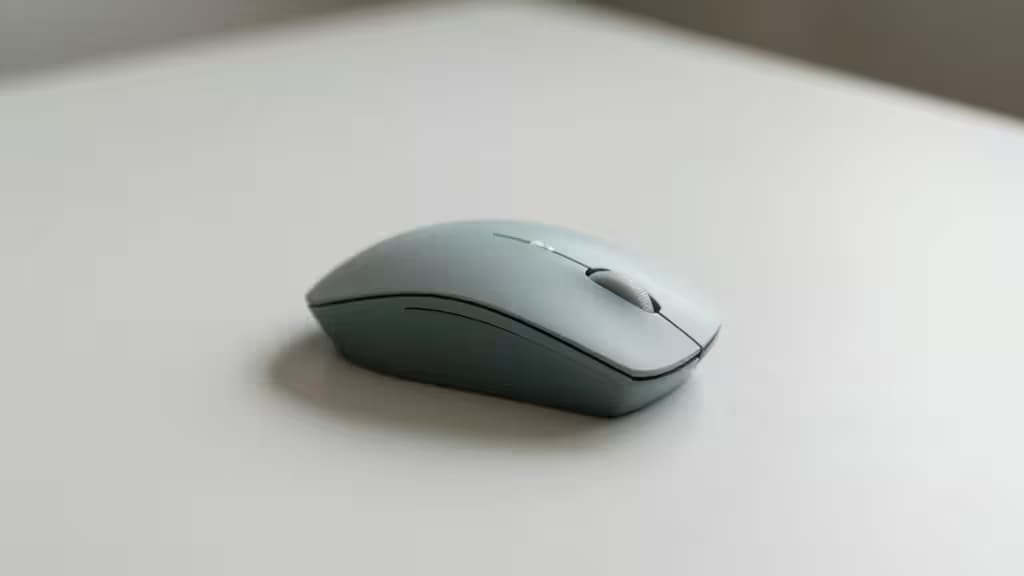 A compact wireless vertical ergonomic mouse resting on a clean minimalist desk surface with soft natural lighting